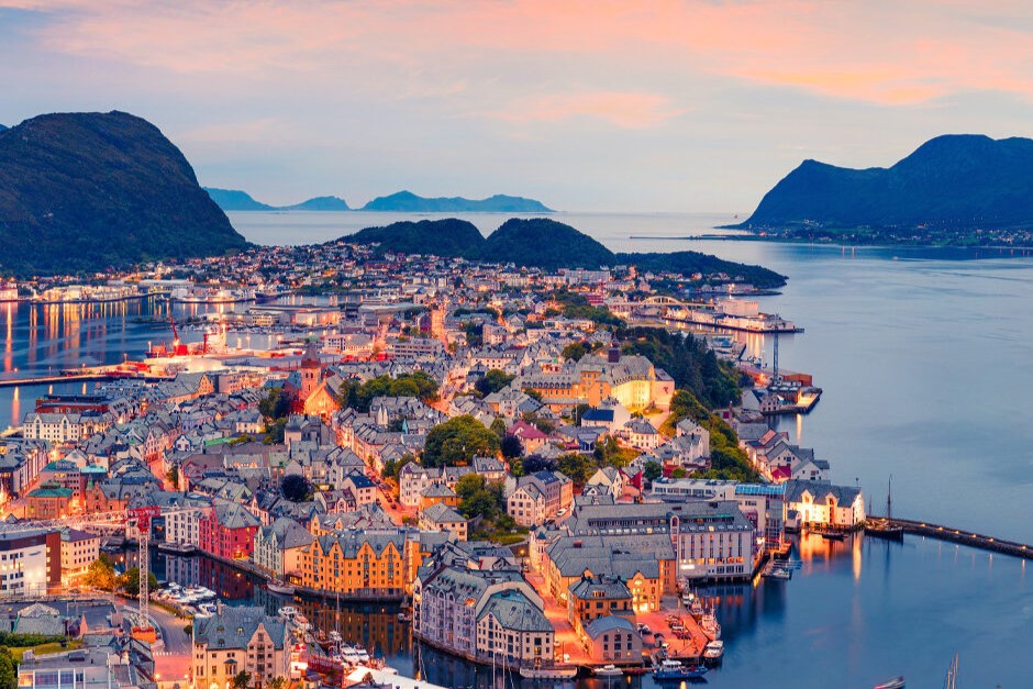 Een schilderachtig uitzicht op Bergen, Noorwegen, badend in de warme kleuren van de zonsondergang, met de charmante architectuur en omliggende bergen.