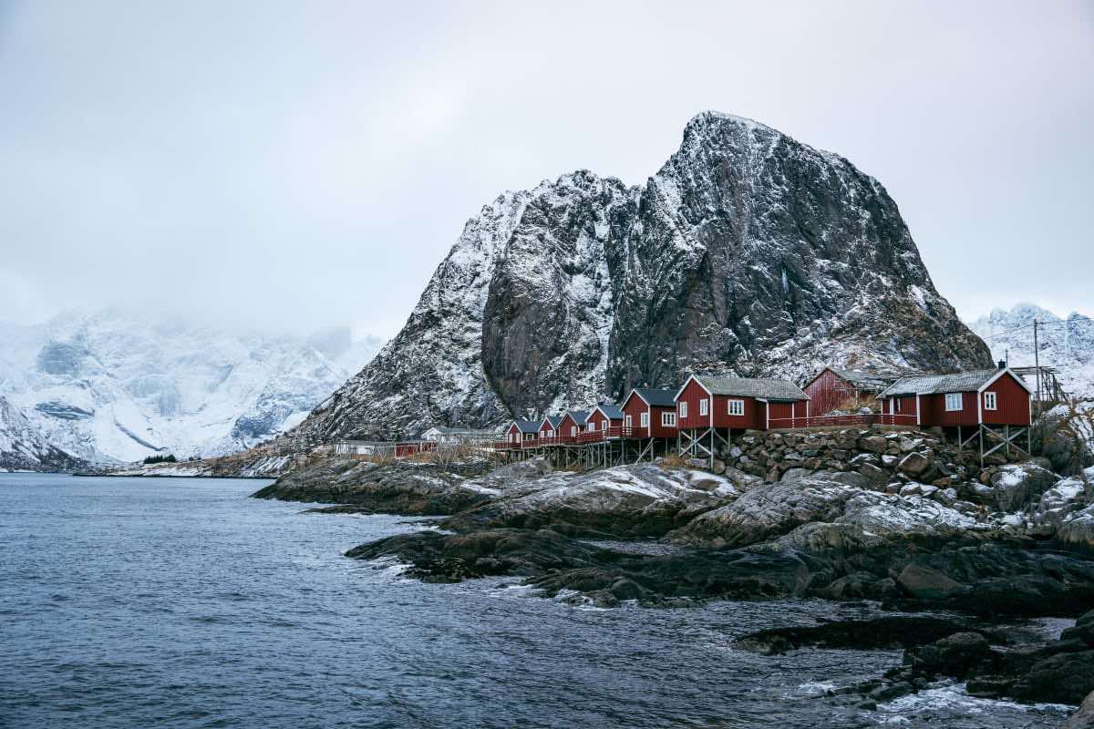 Schilderachtig uitzicht op de Lofoten-eilanden in Noorwegen, met dramatische pieken en kalm water onder een heldere lucht.
