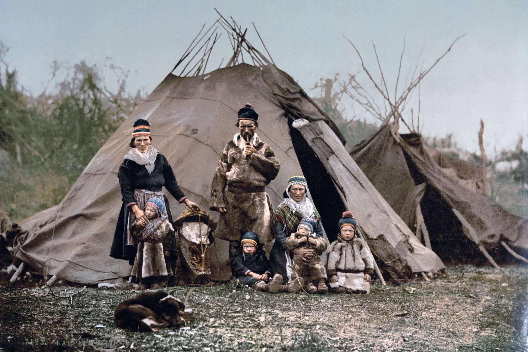 Een vintage familiefoto van leden die samen poseren voor een canvas tent, een moment in de tijd vastgelegd.